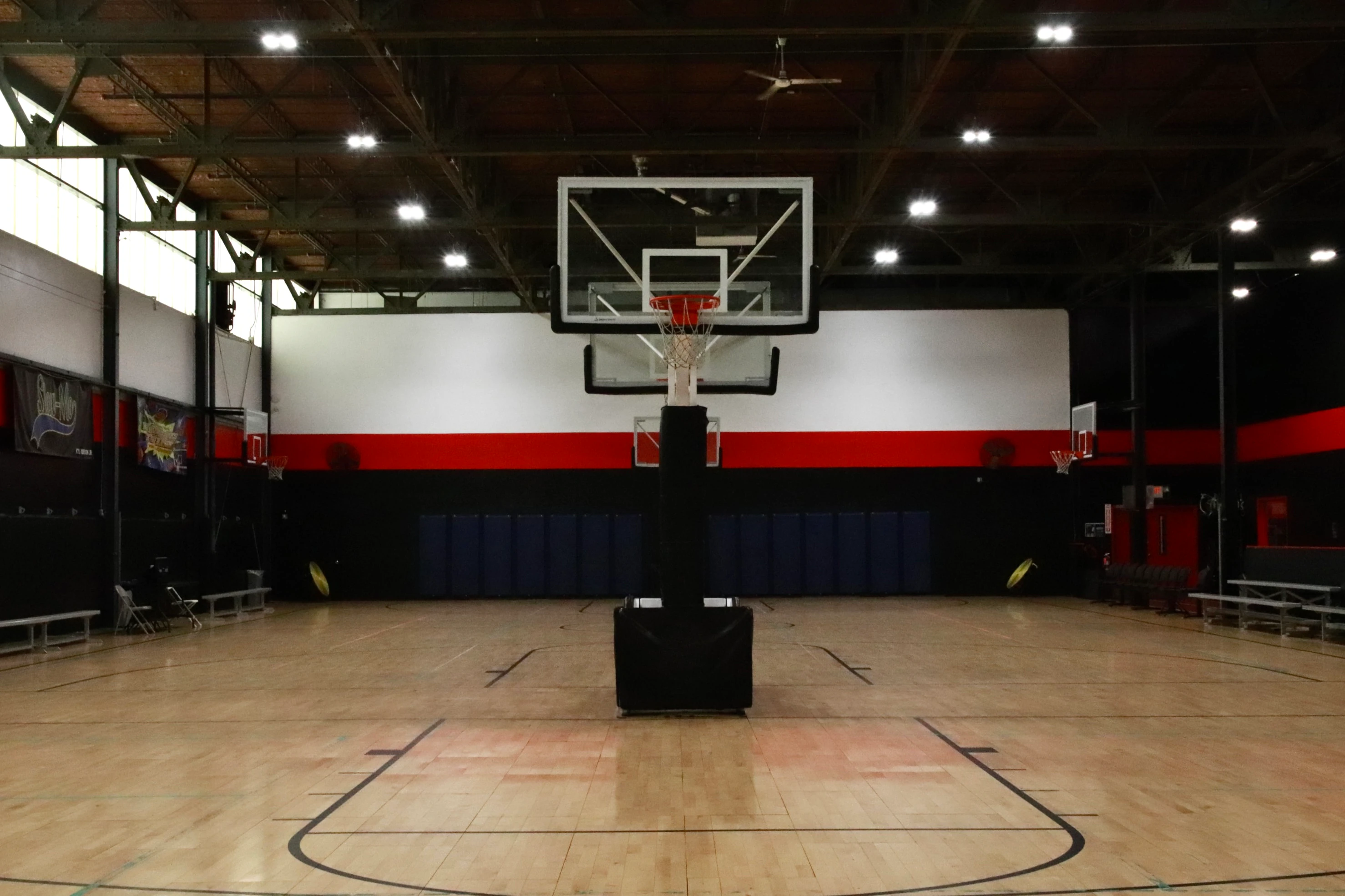 Regulation basketball hoop over the hardwood court at XCEL Sports & Fitness in Fairfield, NJ