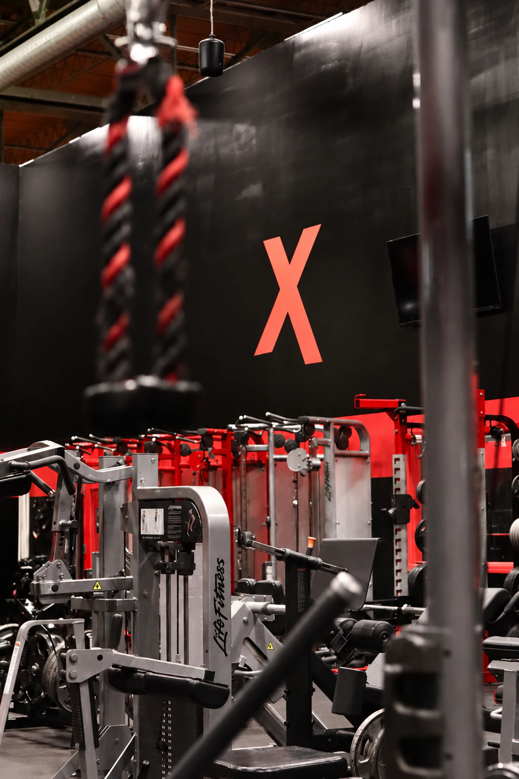 Battle rope hanging in front of Life Fitness selectorized machines under the red X at XCEL in Fairfield, NJ