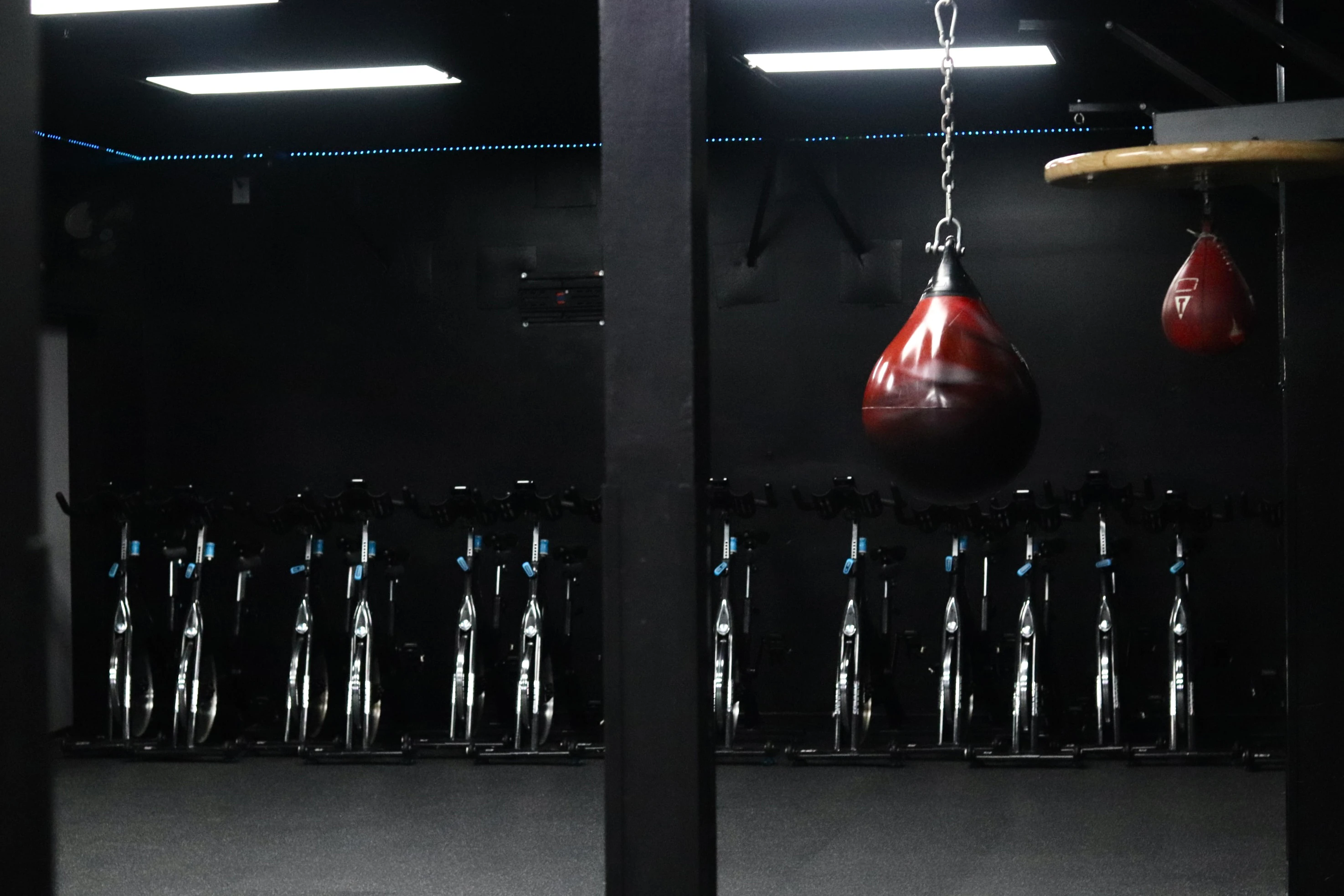 Indoor cycle studio with spin bikes and a heavy bag at XCEL Sports & Fitness in Fairfield, NJ
