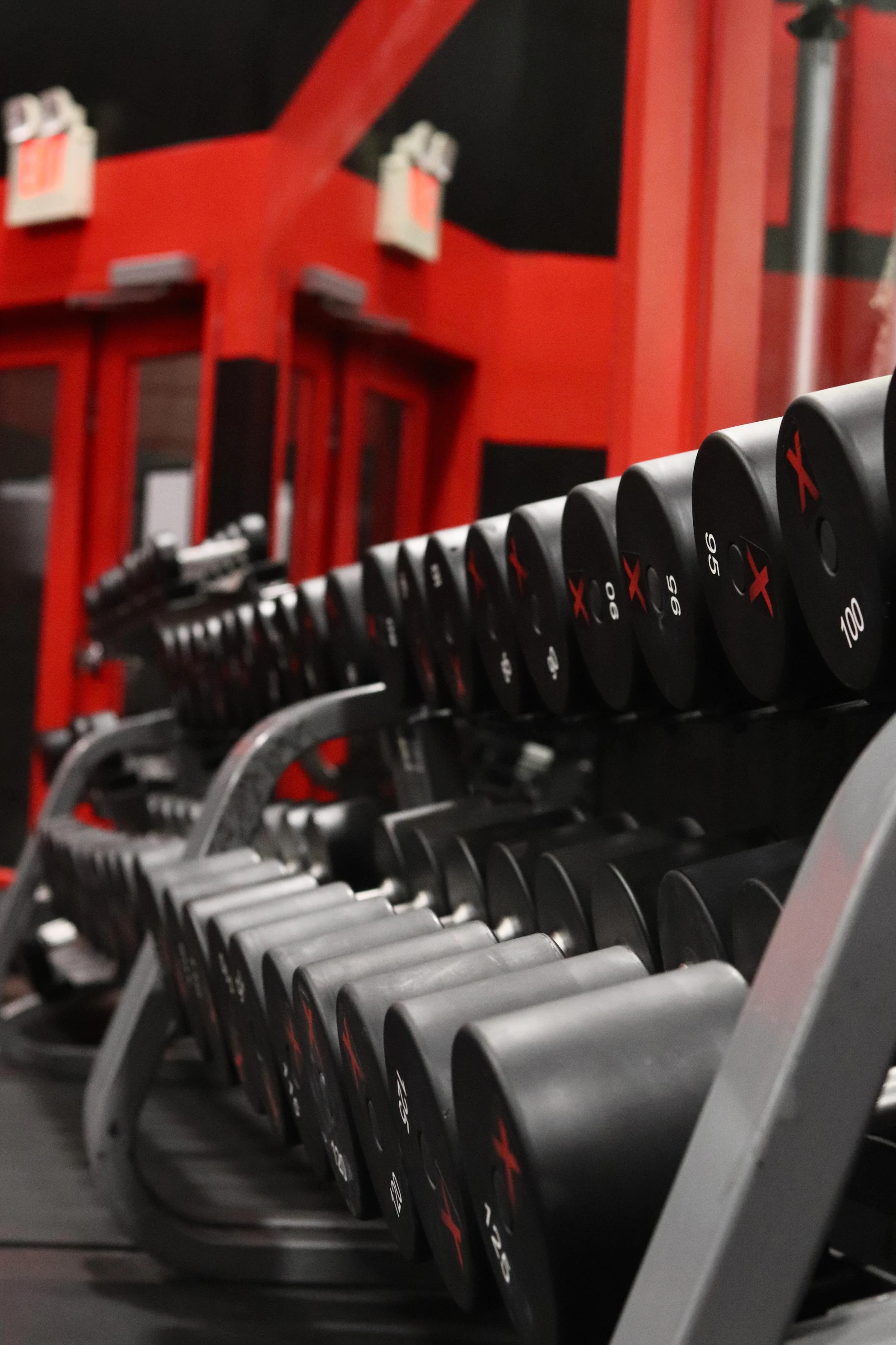 Close-up of a row of XCEL dumbbells on the rack at XCEL Sports & Fitness, a gym in Fairfield, NJ