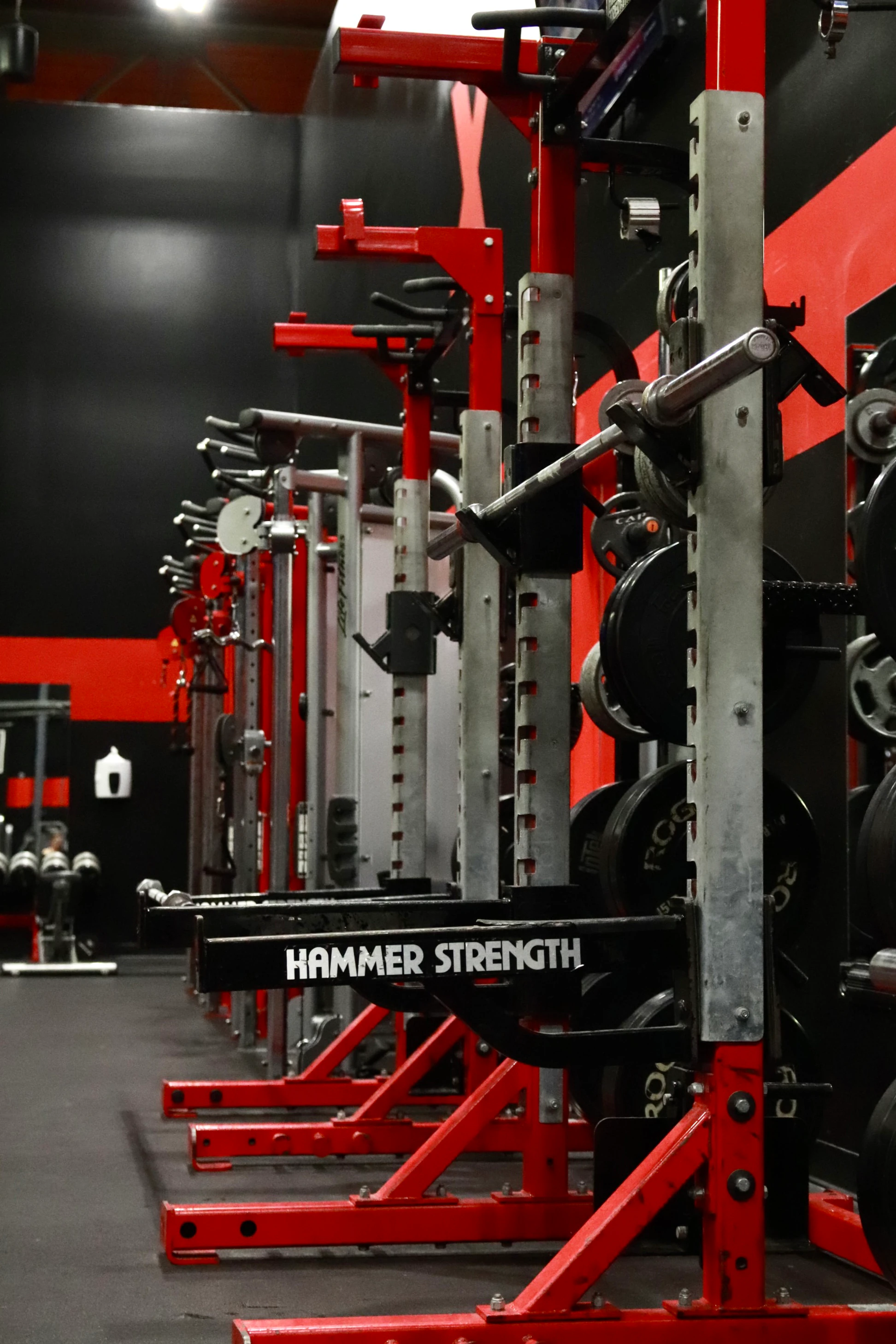 Barbell racked on a red Hammer Strength squat rack at XCEL Sports & Fitness in Fairfield, NJ