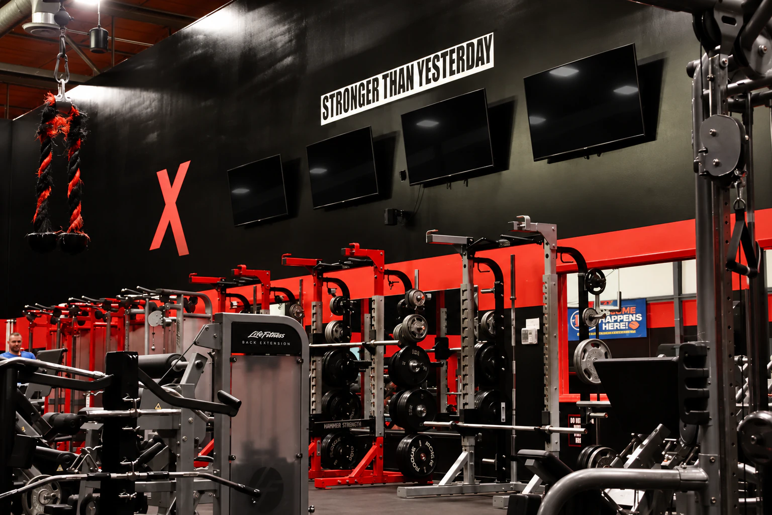 Hammer Strength racks, cable machines and a battle rope on the strength floor at XCEL in Fairfield, NJ