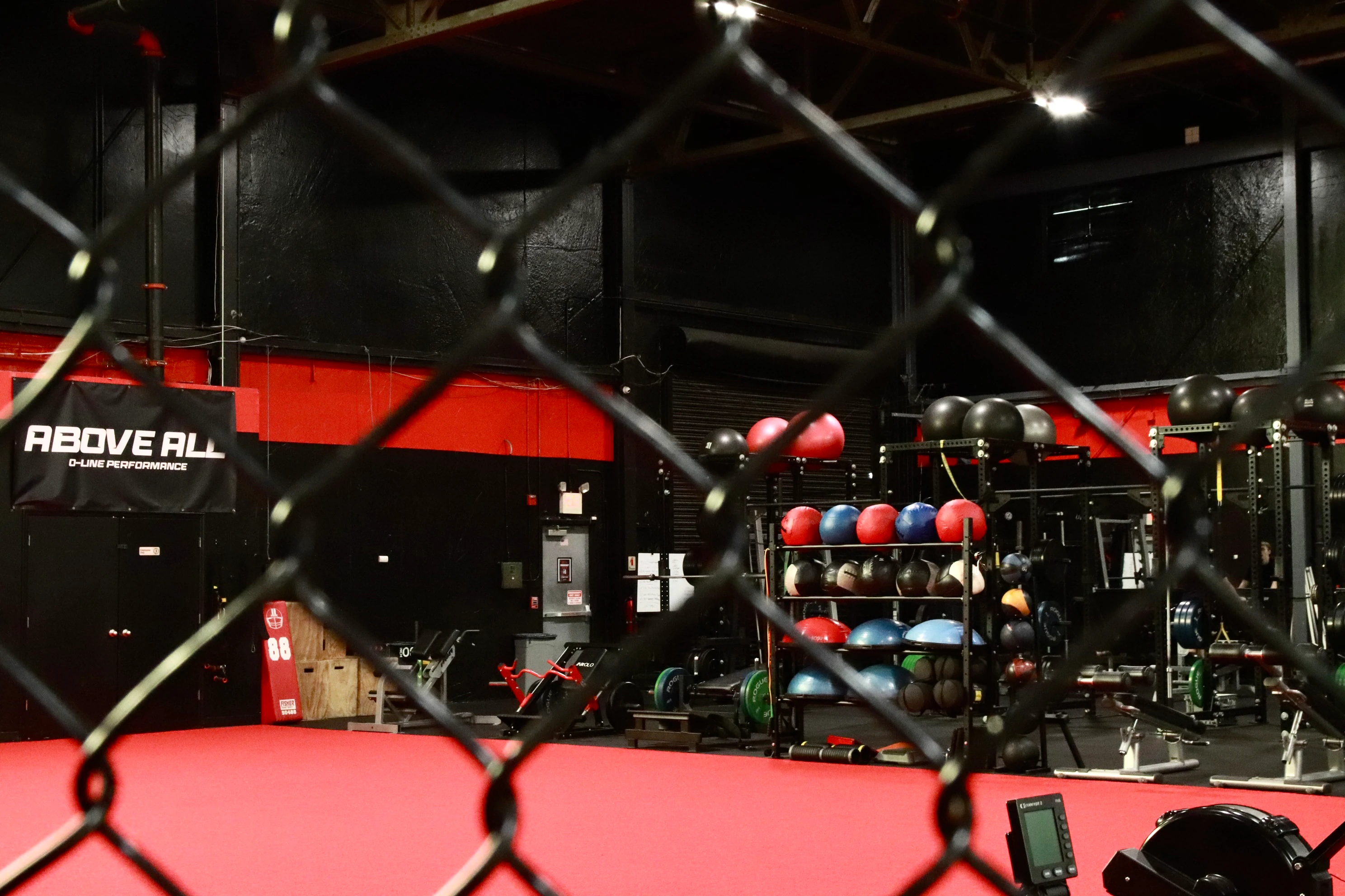 Sports performance turf and medicine ball rack seen through the fence at XCEL in Fairfield, NJ