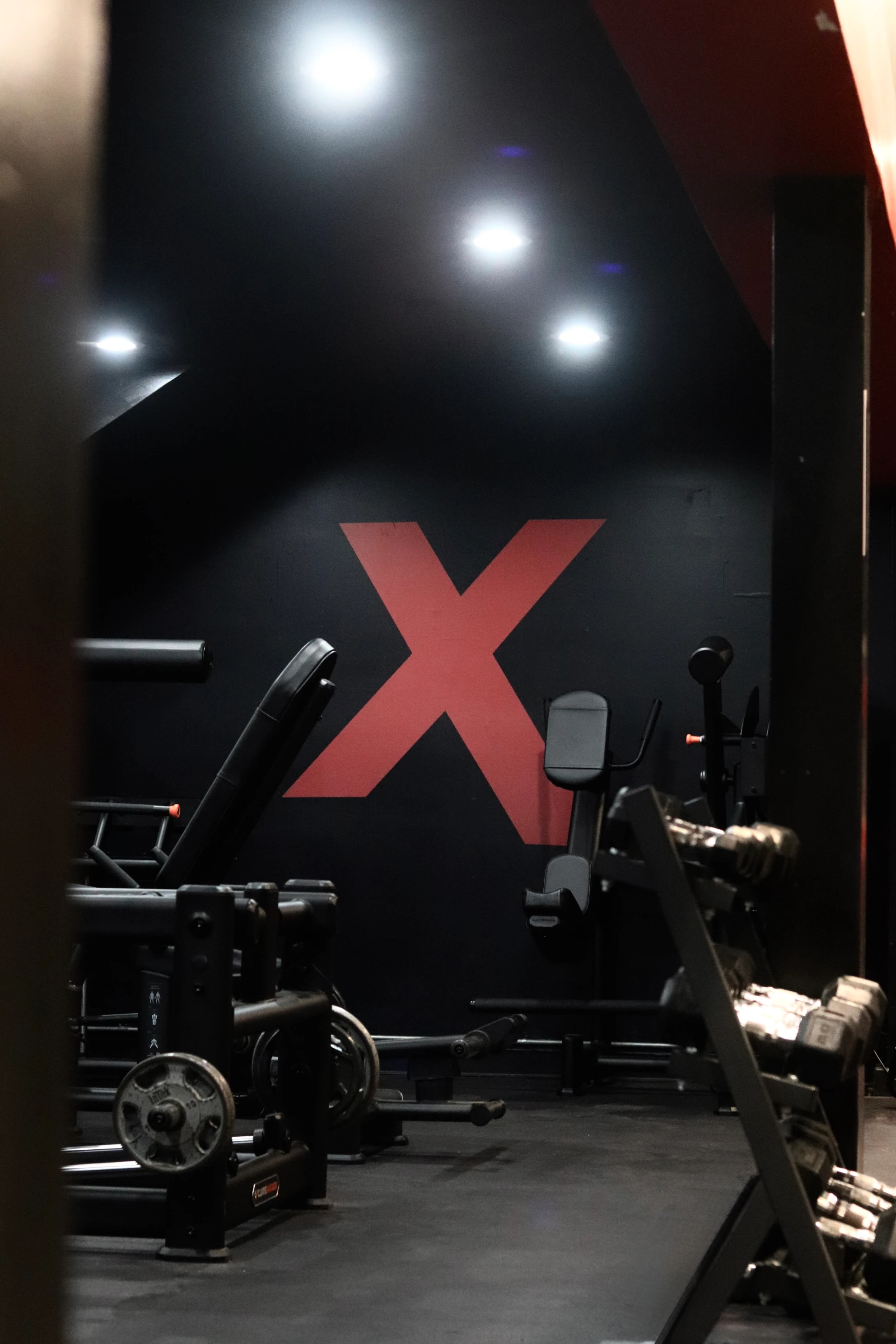 Plate-loaded machines under the red X in a strength room at XCEL Sports & Fitness in Fairfield, NJ
