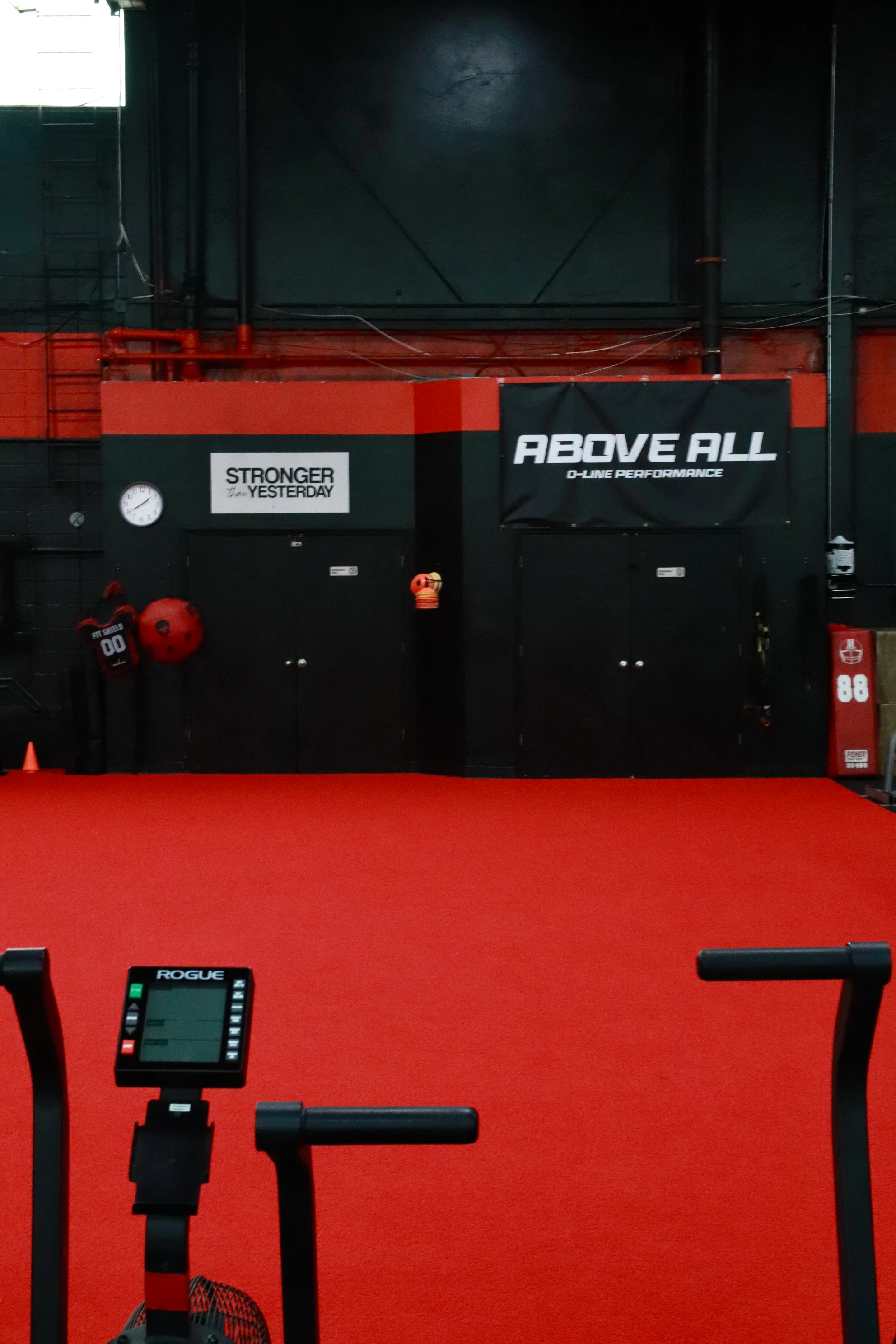 Rogue Echo bikes on the red turf by the Above All wall at XCEL Sports & Fitness in Fairfield, NJ