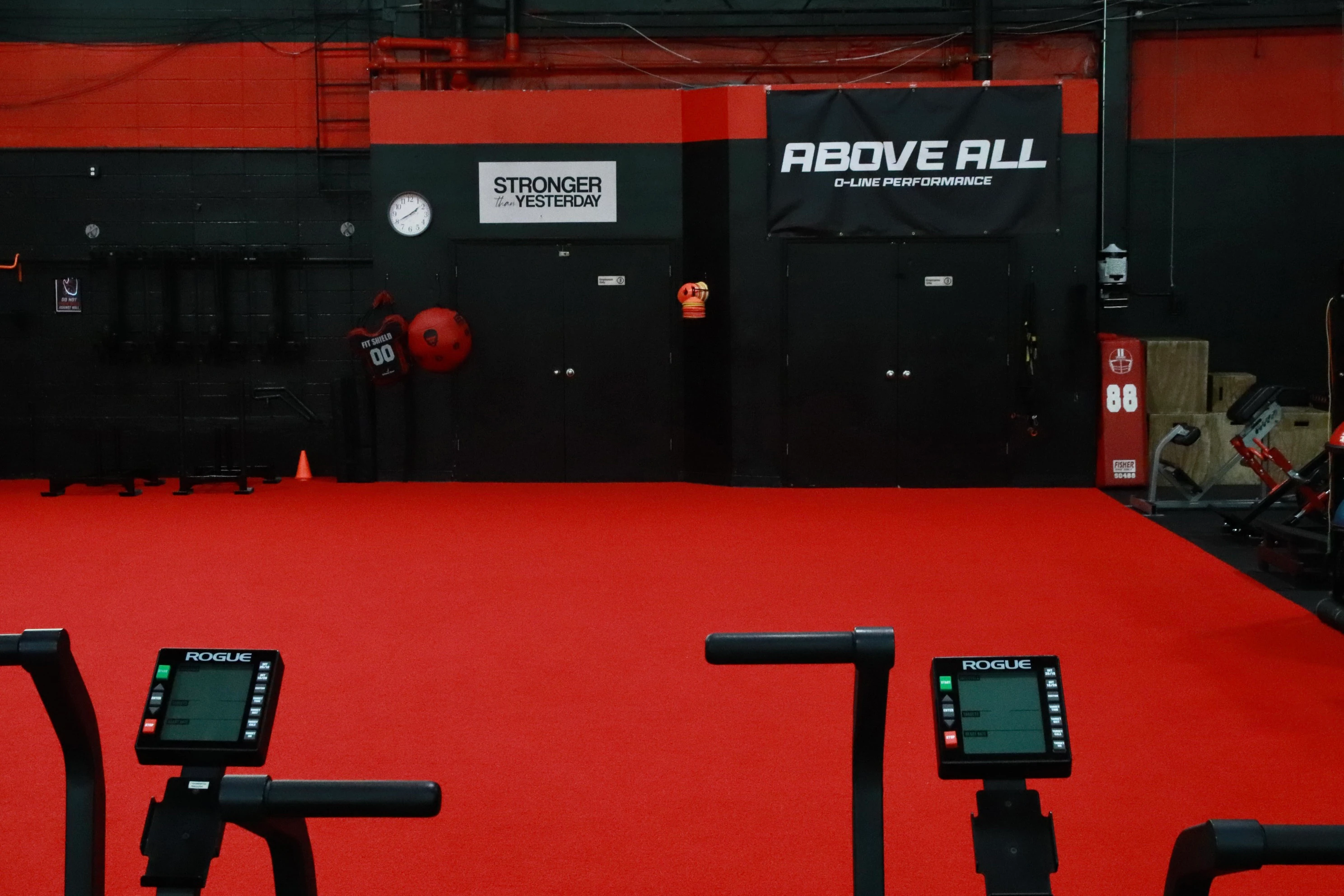Rogue Echo bikes facing the red indoor turf training area at XCEL Sports & Fitness in Fairfield, NJ