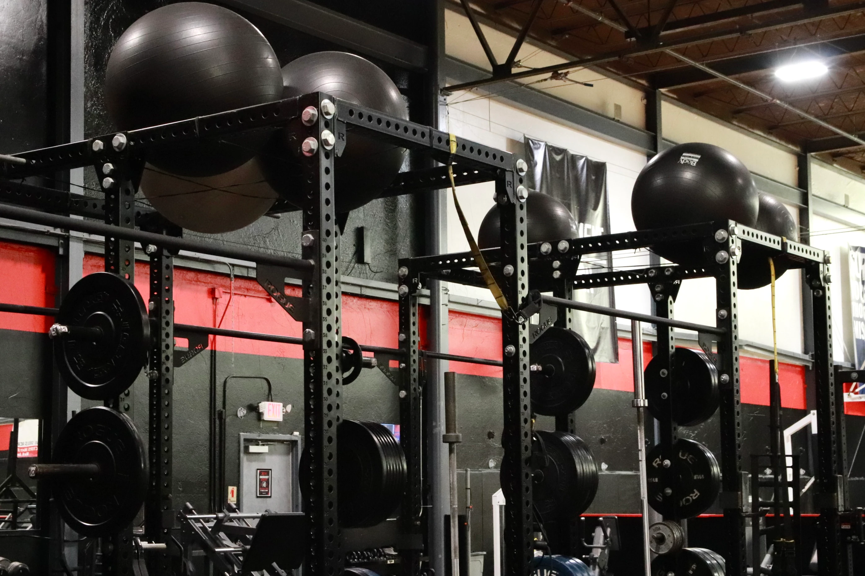 Squat rigs with bumper plates and stability balls on the turf at XCEL Sports & Fitness in Fairfield, NJ