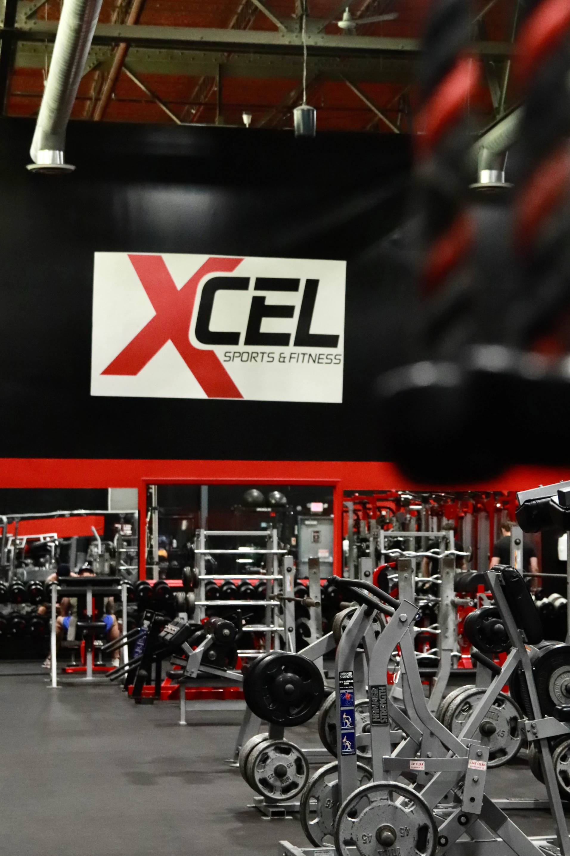 XCEL sign over the strength floor with a battle rope in front at XCEL Sports & Fitness in Fairfield, NJ